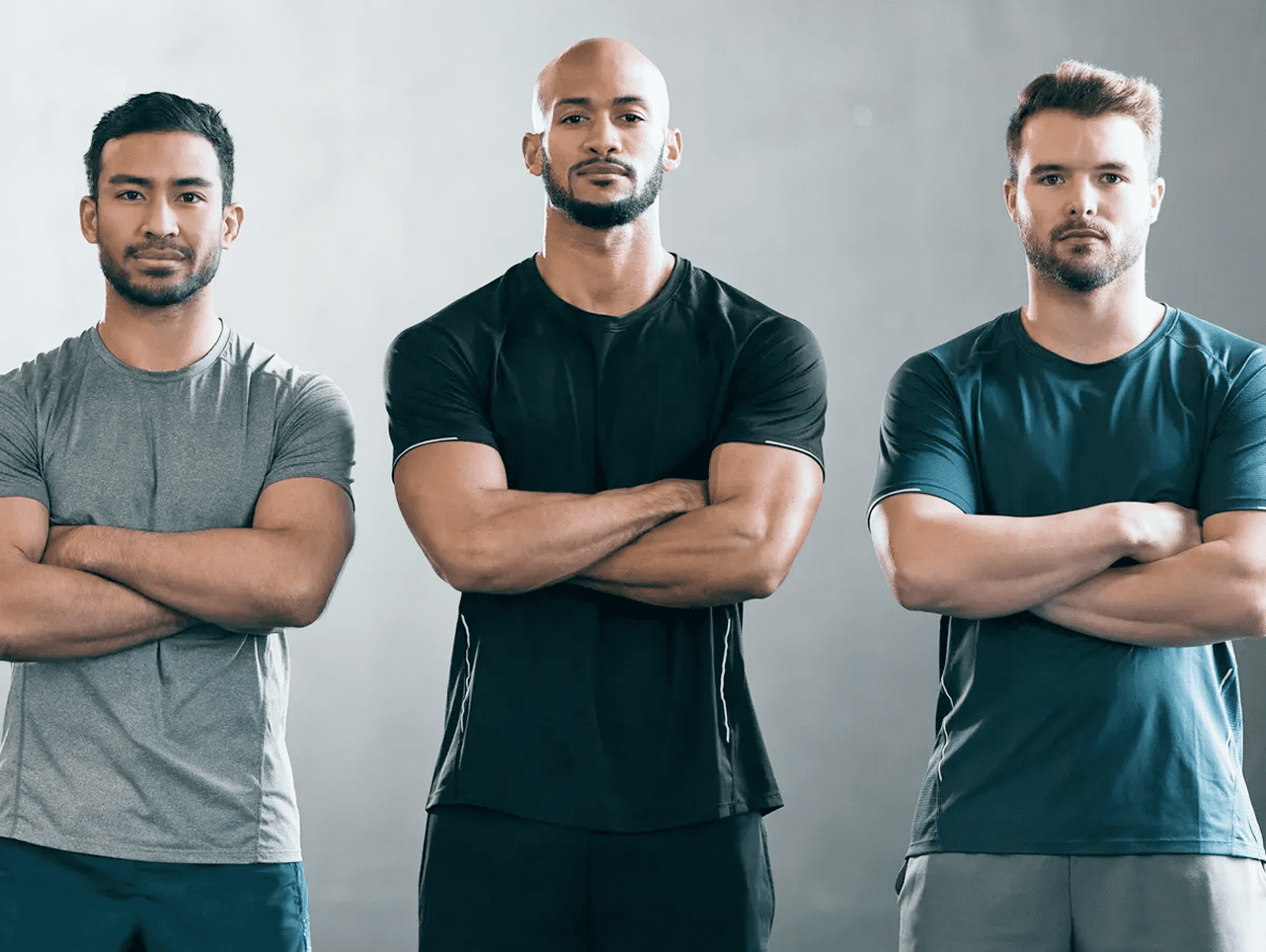 Three men standing with arms crossed.
